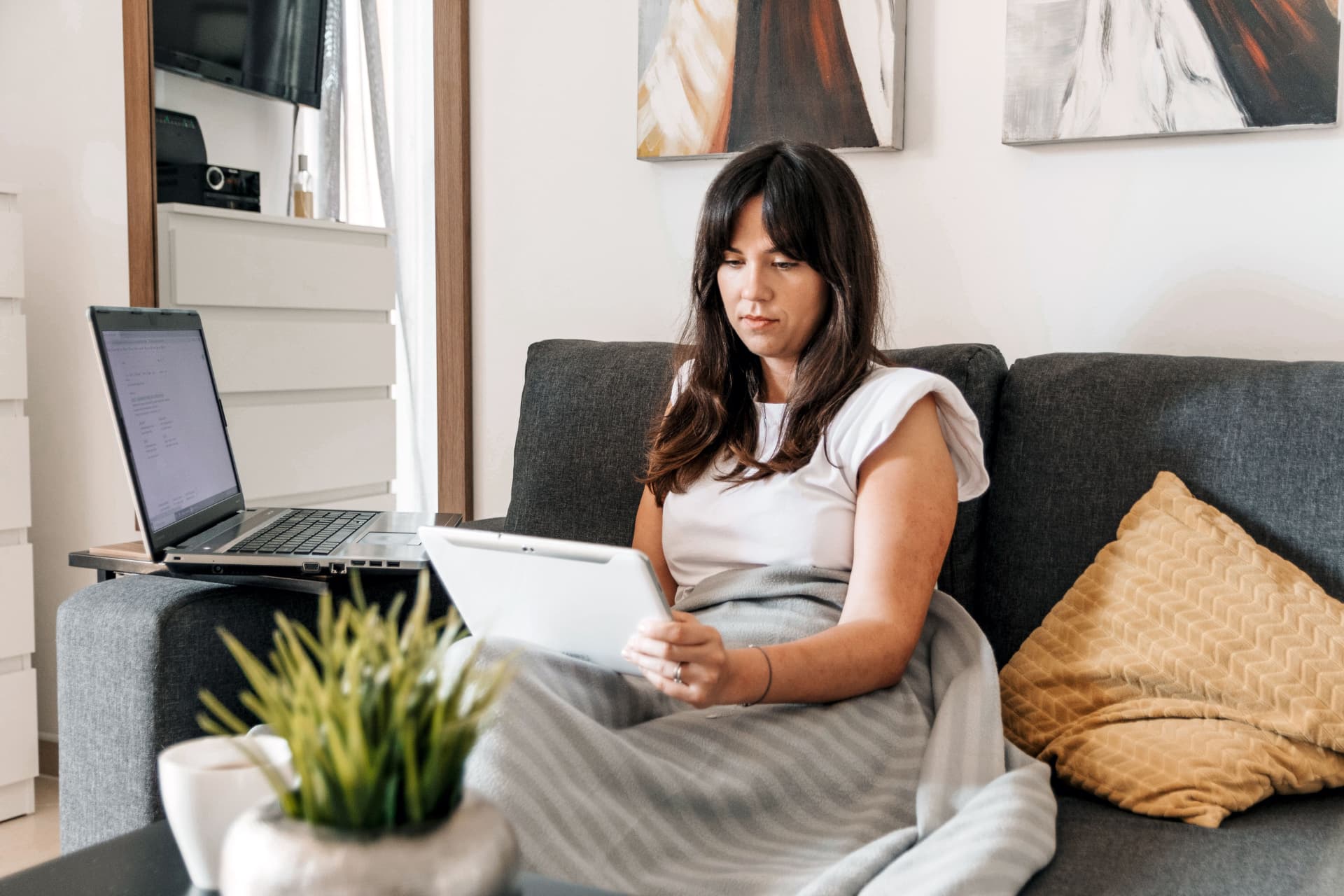 Personne travaillant depuis chez elle avec un ordinateur portable et un téléphone